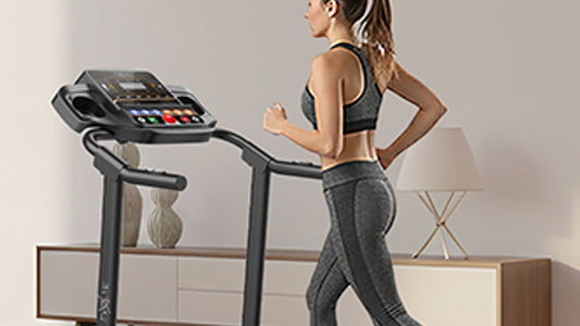 A person runs on a treadmill in a modern home setting.